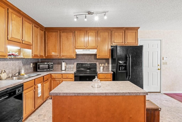 kitchen featuring under cabinet range hood, a sink, light countertops, brown cabinets, and black appliances