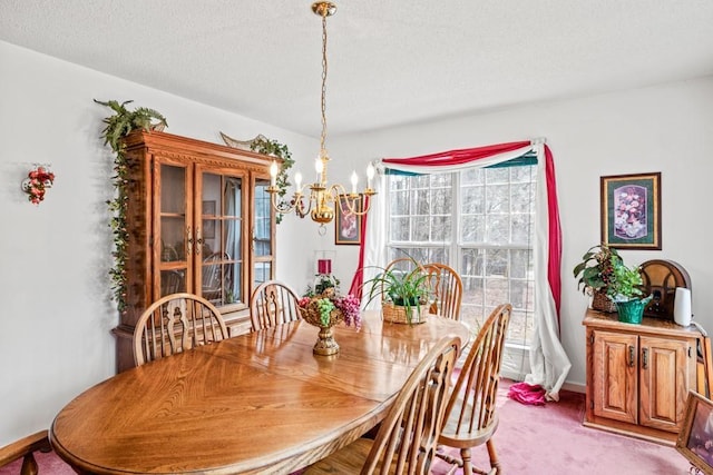 dining room featuring light colored carpet, a notable chandelier, a textured ceiling, and baseboards