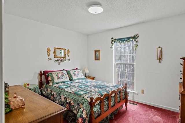 bedroom featuring multiple windows, a textured ceiling, and carpet flooring