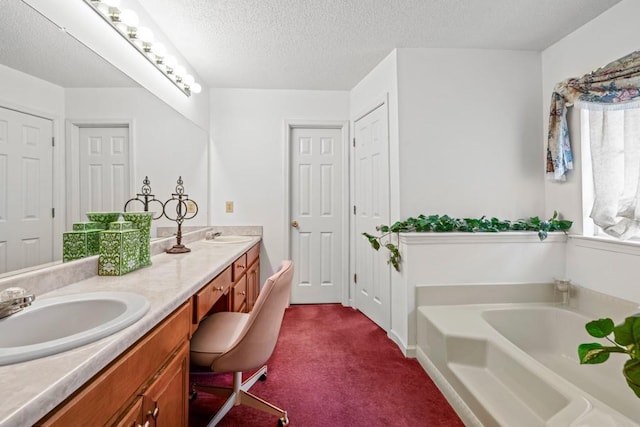 bathroom featuring a garden tub, a sink, a textured ceiling, and double vanity