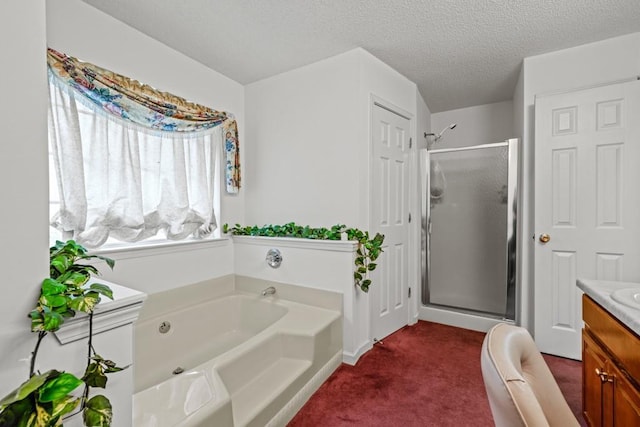 bathroom featuring a stall shower, a textured ceiling, vanity, and a bath