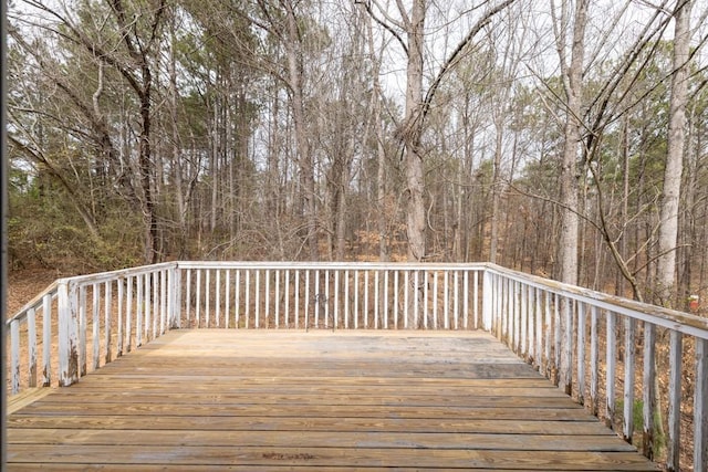 wooden terrace featuring a forest view