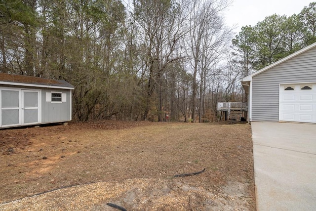 view of yard with an outbuilding, driveway, and a storage unit