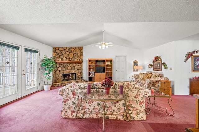 carpeted living area featuring lofted ceiling, a fireplace, a ceiling fan, and a textured ceiling