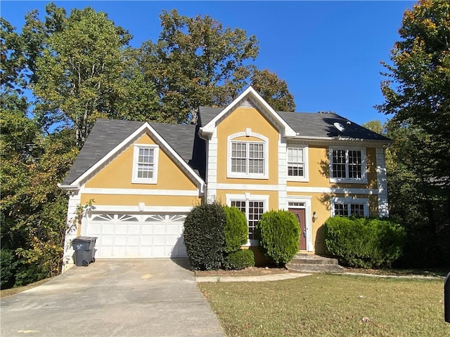 colonial inspired home with a garage and a front lawn