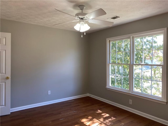 spare room with a textured ceiling, ceiling fan, and dark hardwood / wood-style flooring