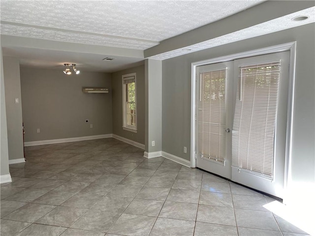 interior space featuring a textured ceiling and light tile patterned flooring