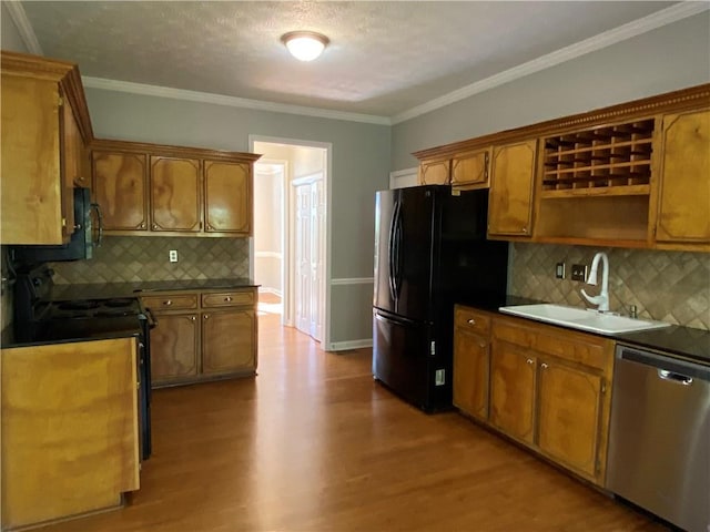 kitchen featuring decorative backsplash, ornamental molding, sink, light hardwood / wood-style floors, and stainless steel appliances