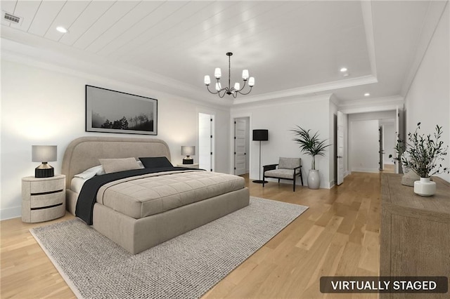bedroom featuring light wood finished floors, visible vents, a tray ceiling, and an inviting chandelier