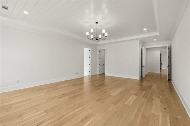 spare room featuring baseboards, visible vents, light wood finished floors, and a chandelier