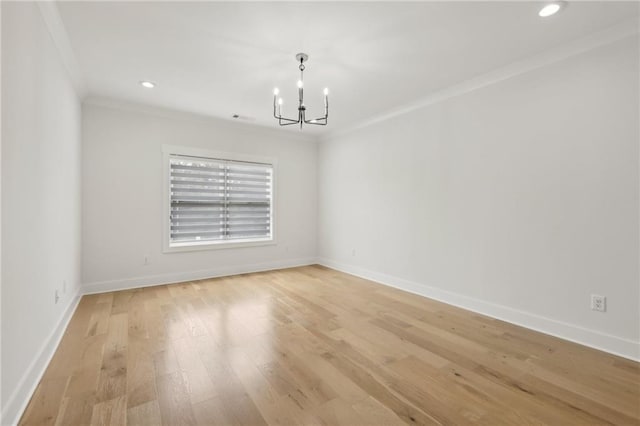 spare room with baseboards, light wood-type flooring, an inviting chandelier, and ornamental molding