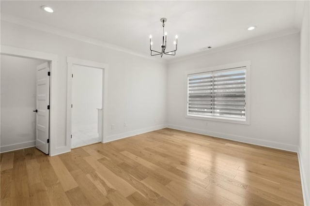 spare room featuring light wood-type flooring, ornamental molding, recessed lighting, an inviting chandelier, and baseboards