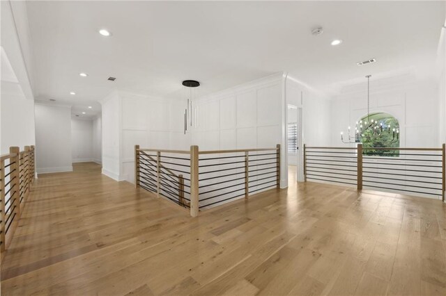unfurnished room with recessed lighting, a notable chandelier, light wood-style flooring, and visible vents