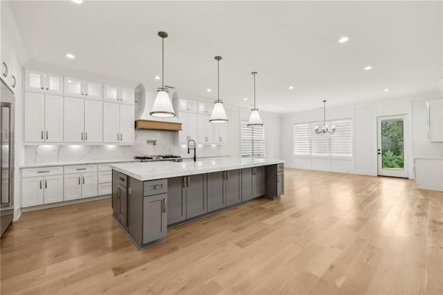 kitchen featuring tasteful backsplash, light wood finished floors, gray cabinetry, and white cabinetry