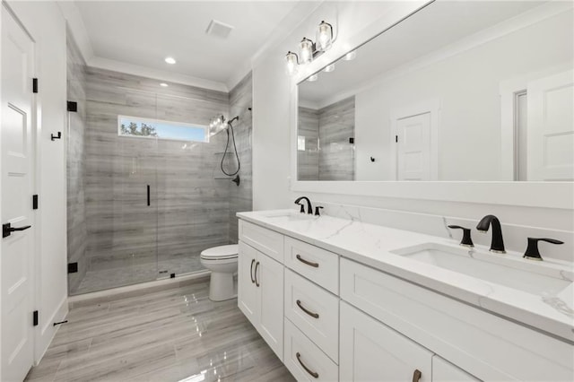 full bath featuring a sink, toilet, a shower stall, and crown molding