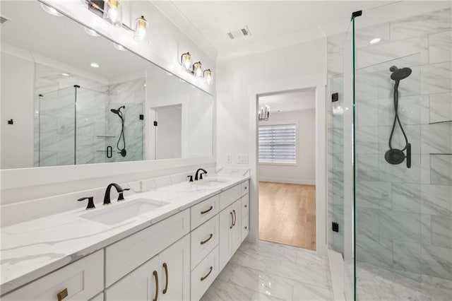 bathroom with a sink, marble finish floor, a stall shower, and double vanity