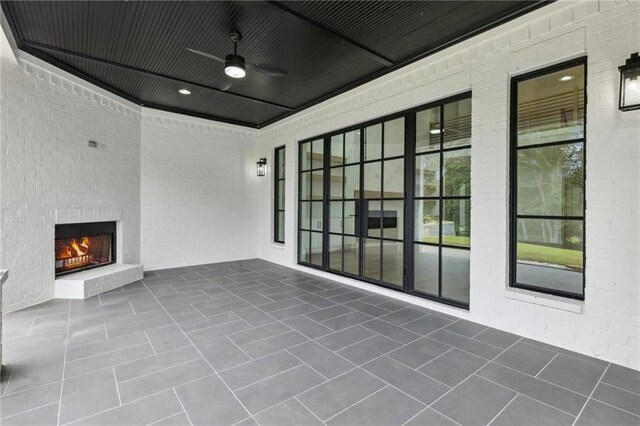 view of patio featuring a ceiling fan and an outdoor brick fireplace