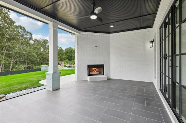 view of patio with a ceiling fan and an outdoor brick fireplace