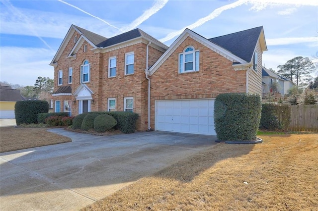 view of front of property featuring concrete driveway, brick siding, fence, and an attached garage