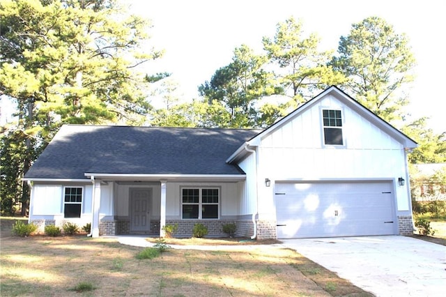 view of front facade featuring brick siding, roof with shingles, concrete driveway, board and batten siding, and a garage