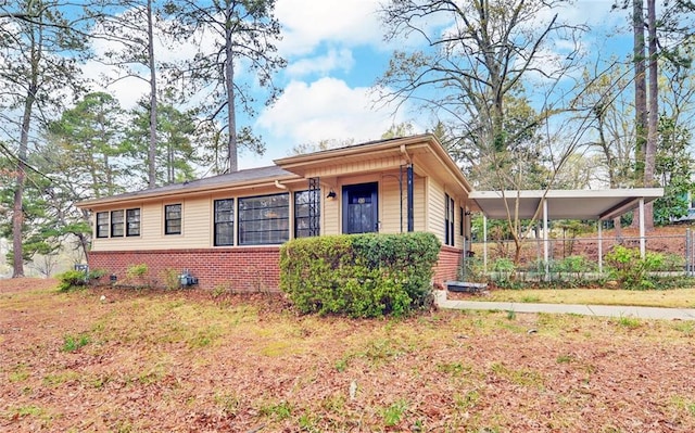 ranch-style house featuring fence and brick siding