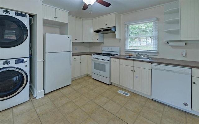 kitchen with stacked washer / drying machine, white appliances, under cabinet range hood, a sink, and visible vents