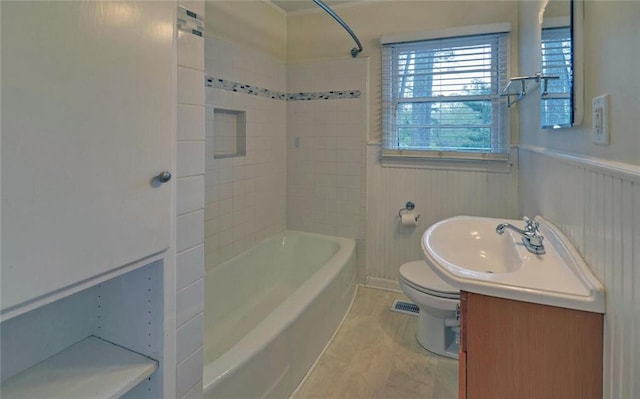 bathroom with a wainscoted wall, vanity, toilet, and shower / bathing tub combination