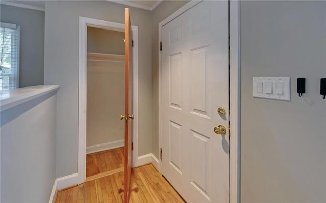 interior space with ornamental molding, baseboards, and light wood-type flooring