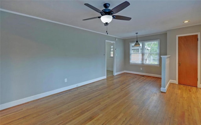 spare room with crown molding, light wood finished floors, baseboards, ceiling fan, and recessed lighting