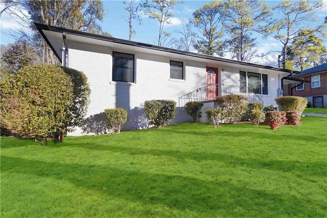 view of front of home with a front yard and brick siding