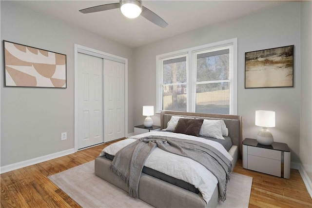 bedroom featuring baseboards, a closet, ceiling fan, and wood finished floors