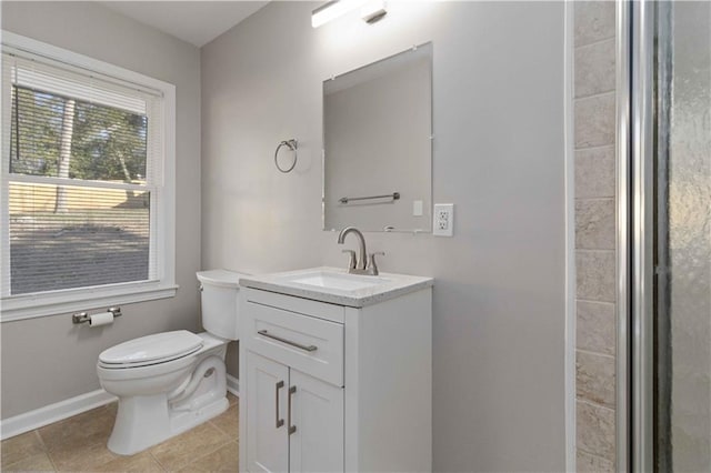 bathroom featuring toilet, baseboards, vanity, and tile patterned flooring