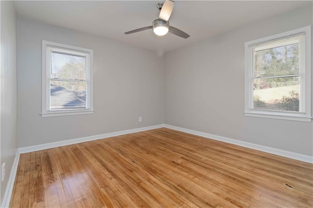 spare room featuring a ceiling fan, baseboards, and light wood-style flooring