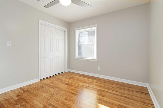 unfurnished bedroom featuring baseboards, light wood-style floors, a closet, and a ceiling fan