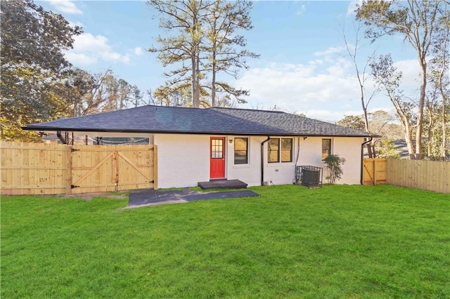 back of house featuring a fenced backyard, a gate, a yard, and central AC