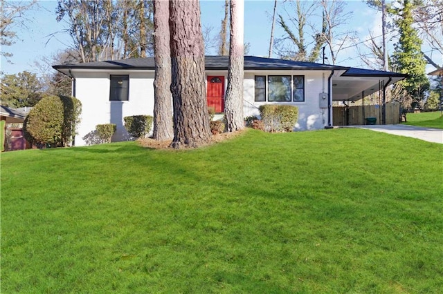 single story home with concrete driveway, a front yard, and an attached carport
