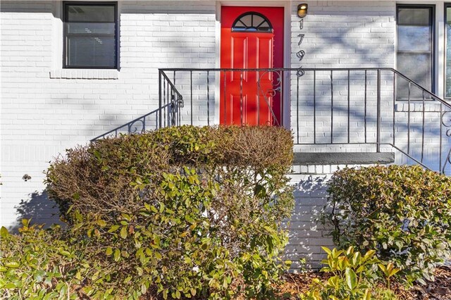 entrance to property featuring brick siding
