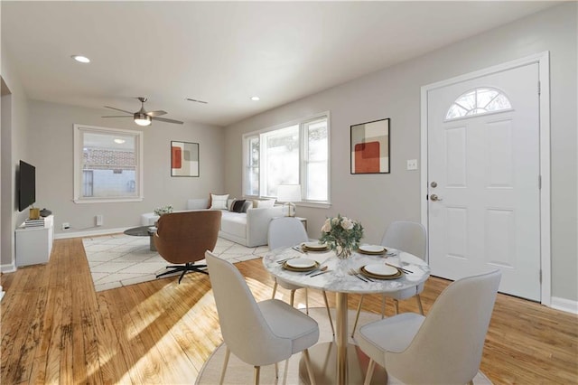 dining room with light wood finished floors, a wealth of natural light, and baseboards