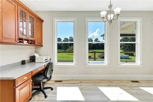 office area with plenty of natural light, light hardwood / wood-style flooring, and a notable chandelier