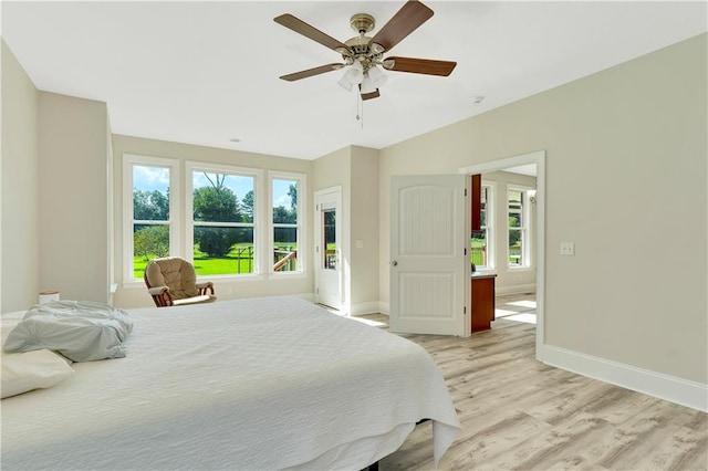 bedroom featuring multiple windows, light wood-type flooring, and ceiling fan