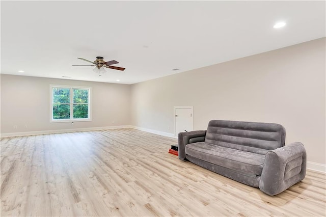 living area with light hardwood / wood-style flooring and ceiling fan