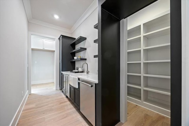 indoor bar with dishwasher, light wood-style floors, crown molding, and baseboards