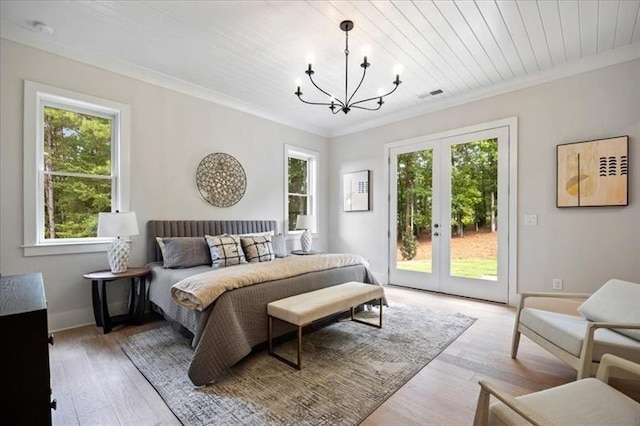 bedroom featuring french doors, access to exterior, a chandelier, ornamental molding, and light wood-style flooring