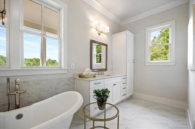 bathroom featuring marble look tiles, vanity, a freestanding tub, and crown molding
