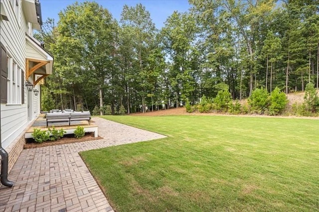 view of green lawn featuring a patio area and an outdoor hangout area