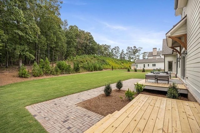 view of green lawn featuring an outdoor living space, a deck, and a patio area