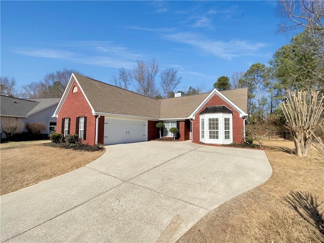 ranch-style house featuring an attached garage, driveway, a chimney, and brick siding