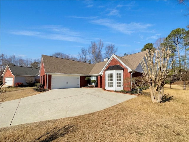 ranch-style home with a garage, a chimney, concrete driveway, and brick siding