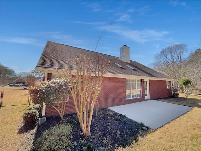 back of house featuring a chimney, roof with shingles, fence, a patio area, and brick siding