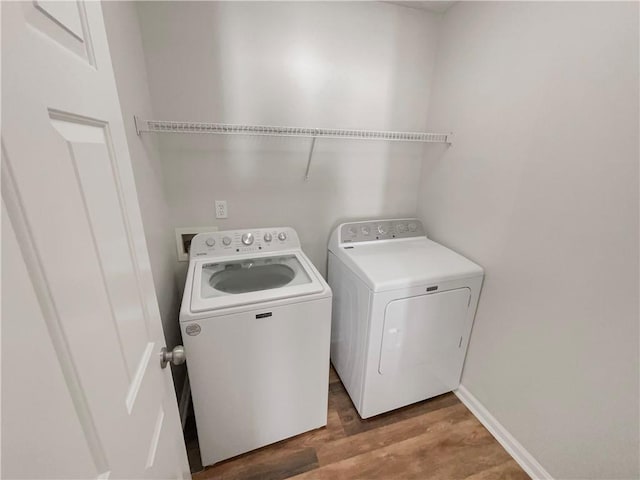 laundry room featuring laundry area, separate washer and dryer, light wood-style flooring, and baseboards